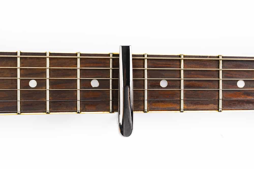 A capo on strings of a fretboard.