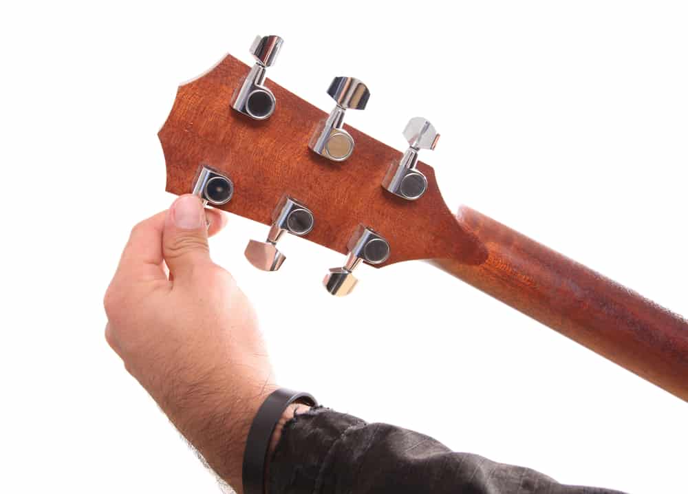 Guitarist tune guitar using pegs on the headstock
