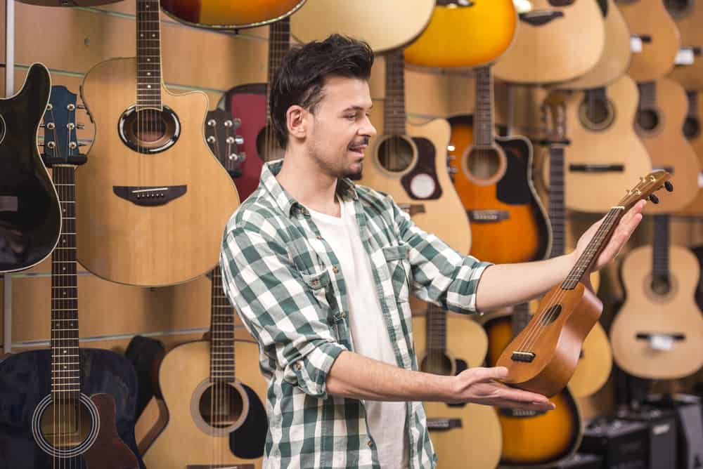 Man choosing ukulele in a music store