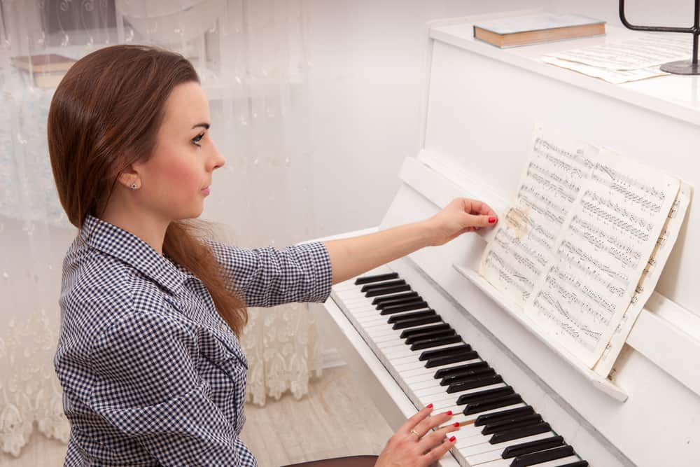 Young attractive girl play piano